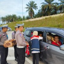 Kasat Lantas Polres Siak Bagikan Air Mineral dan Roti untuk Pemudik di Tol Permai