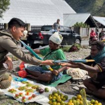 Senyum Mama-Mama Papua Saat Bripda. Rafly Personel Ops Damai Cartenz-2025 Ulurkan Payung