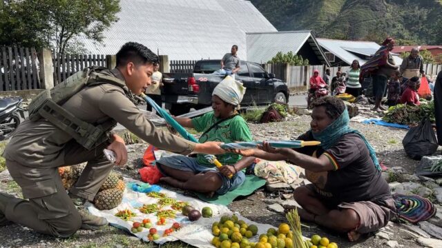 Senyum Mama-Mama Papua Saat Bripda. Rafly Personel Ops Damai Cartenz-2025 Ulurkan Payung